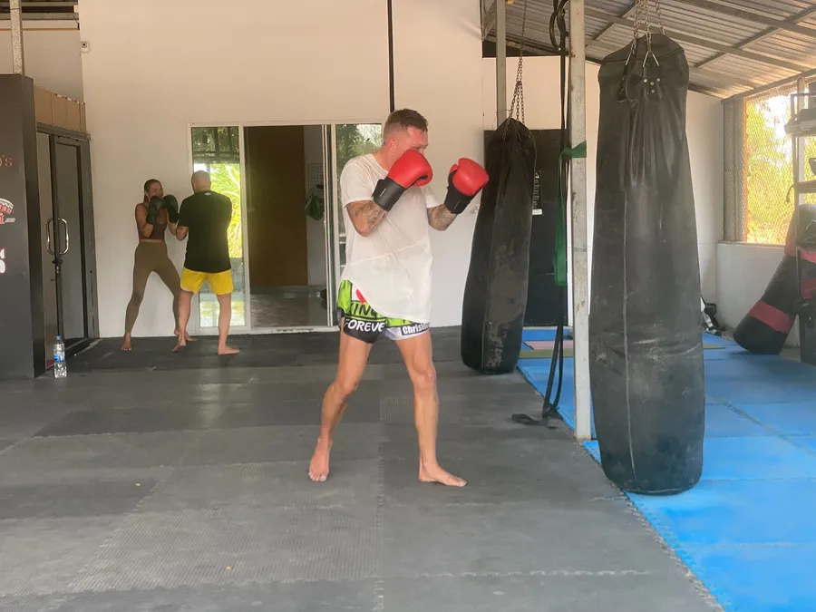 Medarbetare tränar thaiboxning på ett gym i Thailand
